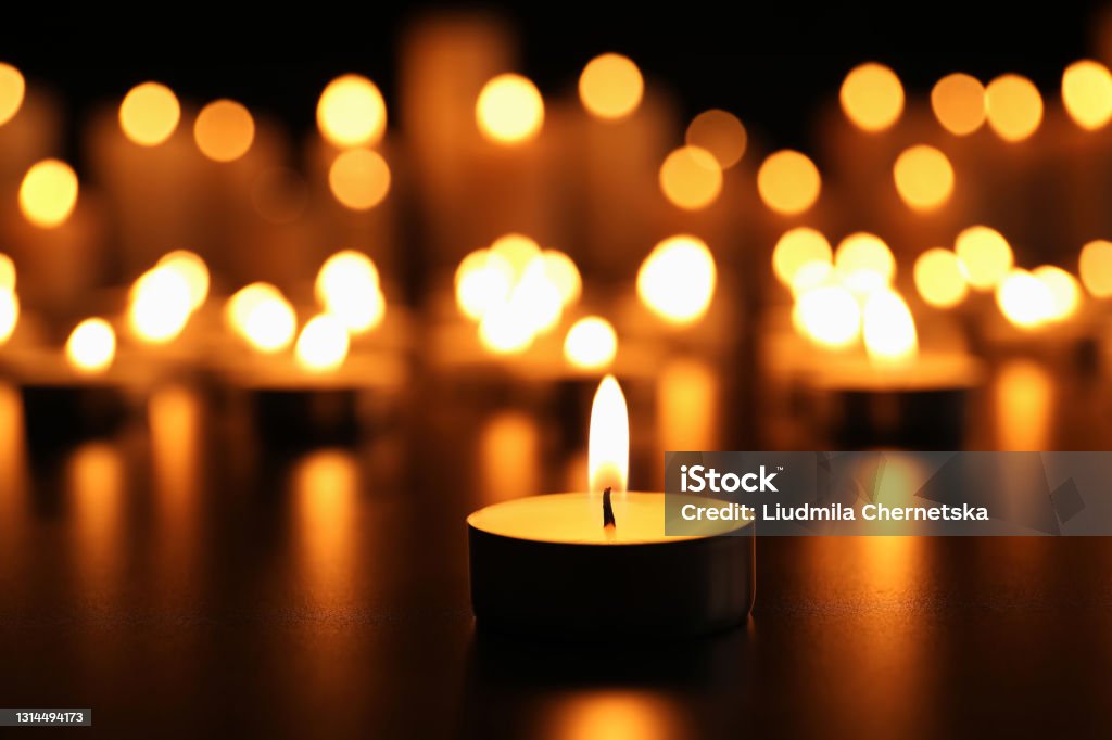 Burning candle on black table. Memory day Candle Stock Photo