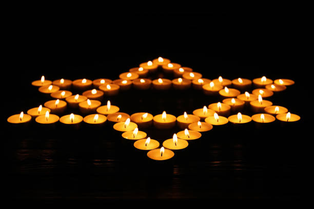 Star of David made with burning candles on black background. Memory day Star of David made with burning candles on black background. Memory day nazism photos stock pictures, royalty-free photos & images
