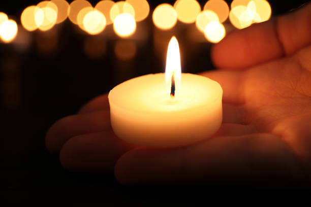 istock Woman with burning candle in darkness, closeup. Memory day 1314495092