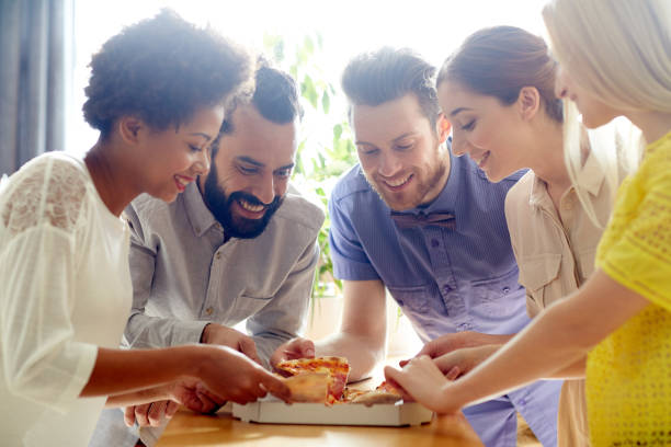 istock happy business team eating pizza in office 1314497670
