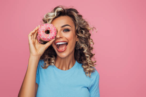 istock Young beautiful woman holding pink donut 1314498925