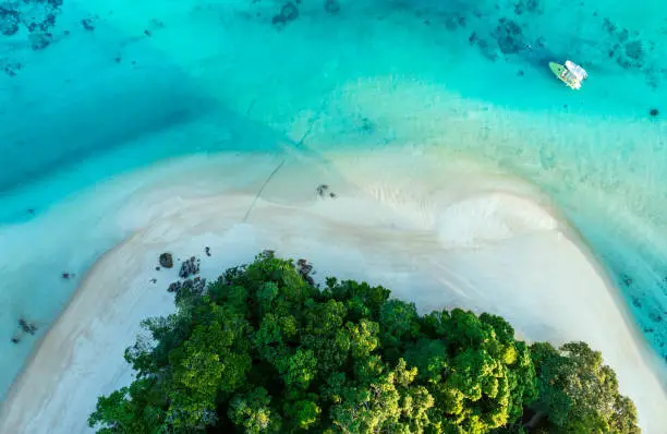 The Tropical island beach which  green lush tropical island in a blue and turquoise sea with islands in the background