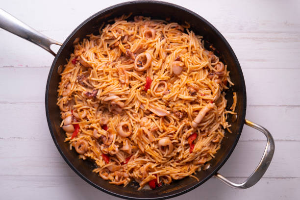 paella con fideua y calamar en un restaurante español - fideua fotografías e imágenes de stock