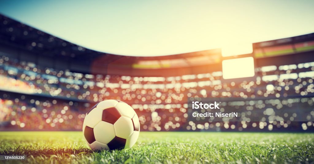 Football soccer ball on grass field on stadium Football soccer ball on grass field on stadium. Sport International Soccer Event Stock Photo