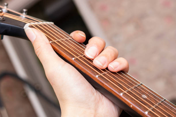 istock Fingers on the strings of black guitar 1314505512
