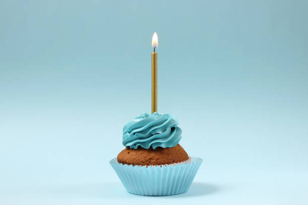 istock Delicious cupcake with a candle on a colored background with space for text. 1314510509