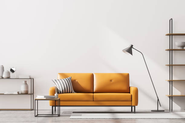 istock Modern living room interior, white wall. Yellow 2 sitter sofa with stripe cushion, coffee table, shelves and lamp. Concrete floor. 1314510661