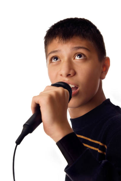 istock Young boy singing karaoke song against white background 1314512565