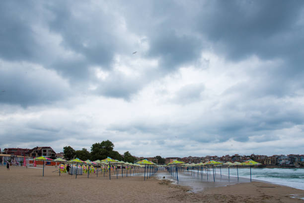 istock Closed umbrellas on a deserted beach in cloudy weather during COVID 1314513344