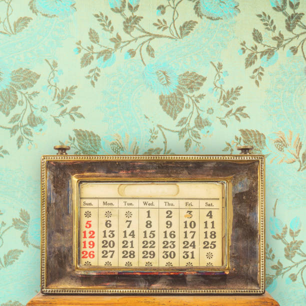 istock Ancient office table calendar in front of vintage blue wallpaper with floral pattern 1314514256