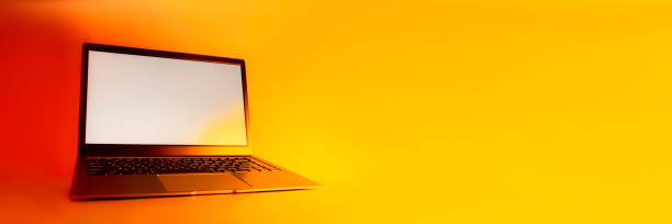 istock Slim modern laptop with white screen Mockup set against bright, red creative light. 1314514289