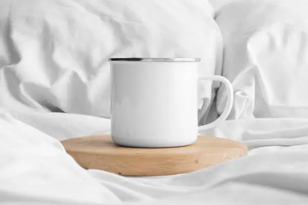 Enamel mug mockup on the bed.