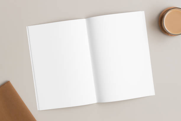 istock Open magazine mockup with a cup of coffee and a notebook on the beige table. 1314516142
