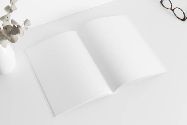 istock Open magazine mockup with a glasses and eucalyptus on the white table. 1314516185