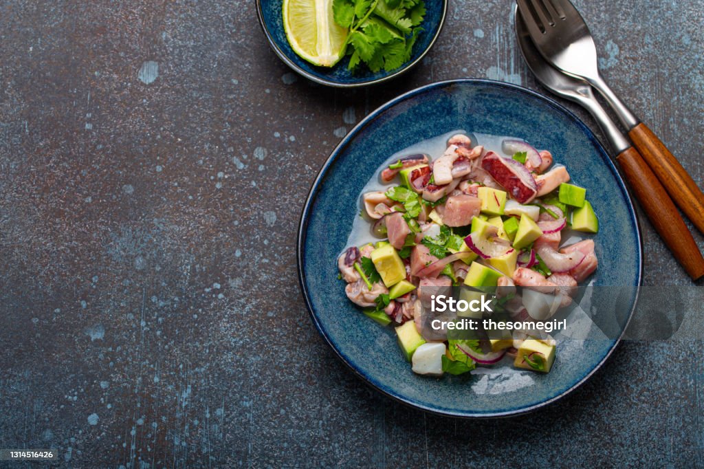 Peruvian ceviche with fresh fish and seafood on plate from above copy space Peruvian ceviche with fresh fish, seafood, avocado on ceramic blue plate on rustic stone background from above, traditional dish of Peru cuisine with space for text Seviche Stock Photo