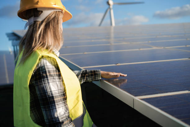 istock Young woman working at alternative energy farm - Focus on architect hand over solar panel 1314517949