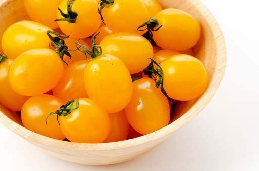 Fresh cherry tomatoes aiko in Wooden bowl on white background