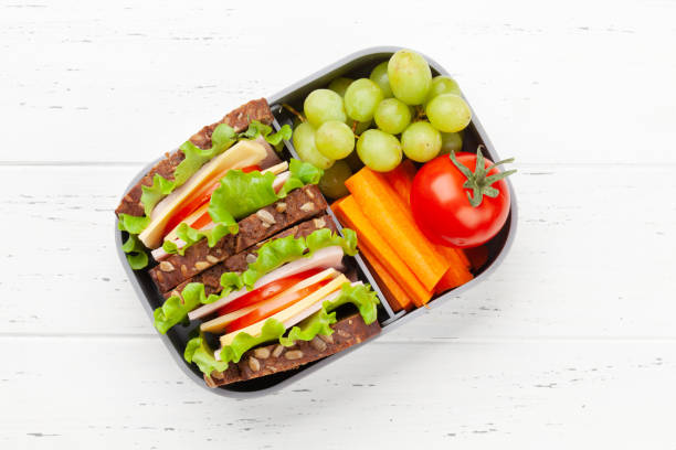 Healthy school lunch box with sandwich and fresh vegetables