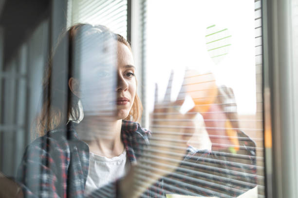 istock Female entrepreneur putting sticky notes with ideas on a window 1314518705