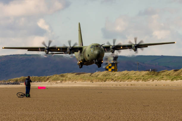 королевские военно-воздушные силы lockheed c-130j 'super hercules' выполняют тактические посадки и взлеты с общественного пляжа в cefn sidan sands в западном уэ� - lockheed c 130 hercules military airplane military british military стоковые фото и изображения