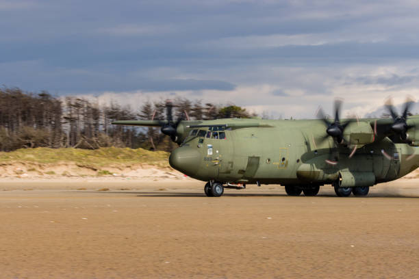 королевские военно-воздушные силы lockheed c-130j 'super hercules' выполняют тактические посадки и взлеты с общественного пляжа в cefn sidan sands в западном уэ� - lockheed c 130 hercules military airplane military british military стоковые фото и изображения