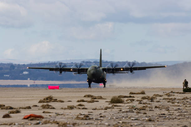 королевские военно-воздушные силы lockheed c-130j 'super hercules' выполняют тактические посадки и взлеты с общественного пляжа в cefn sidan sands в западном уэ� - lockheed c 130 hercules military airplane military british military стоковые фото и из�ображения