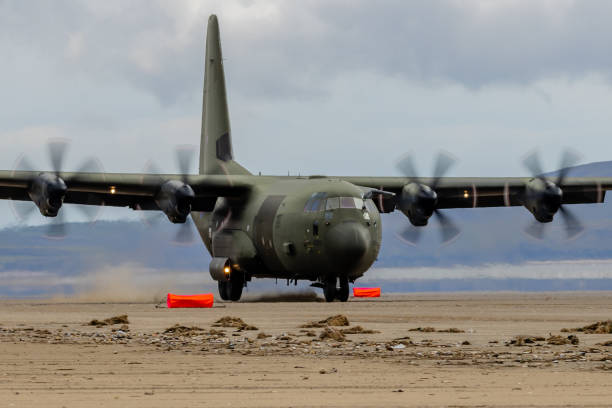 королевские военно-воздушные силы lockheed c-130j 'super hercules' выполняют тактические посадки и взлеты с общественного пл�яжа в cefn sidan sands в западном уэ� - lockheed c 130 hercules military airplane military british military стоковые фото и изображения