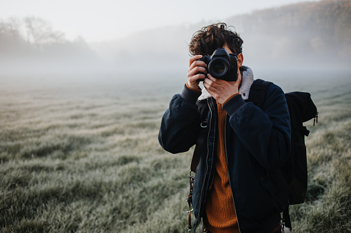 photographer taking pictures on a foggy meadow
