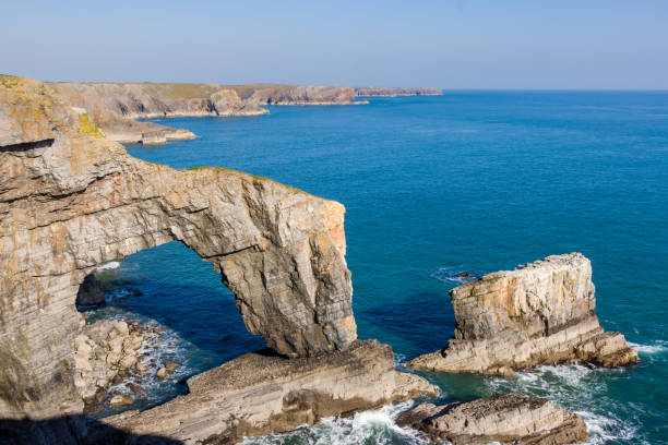 istock Beautiful natural archway and rugged ocean coastline (Green Bridge of Wales, Castlemartin, Pembroke) 1314522518