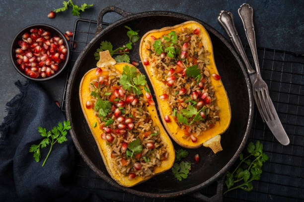 butternut squash stuffed with brown rice and vegetables, served with pomegranate and coriander - butternut squash roasted squash cooked imagens e fotografias de stock