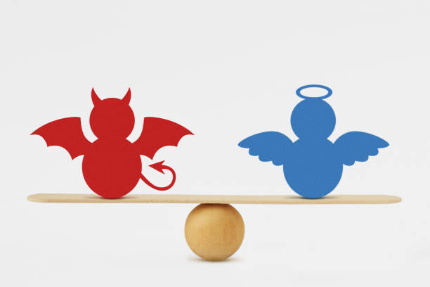 Devil and angel on balance scale - Balance between good and evil stock photo