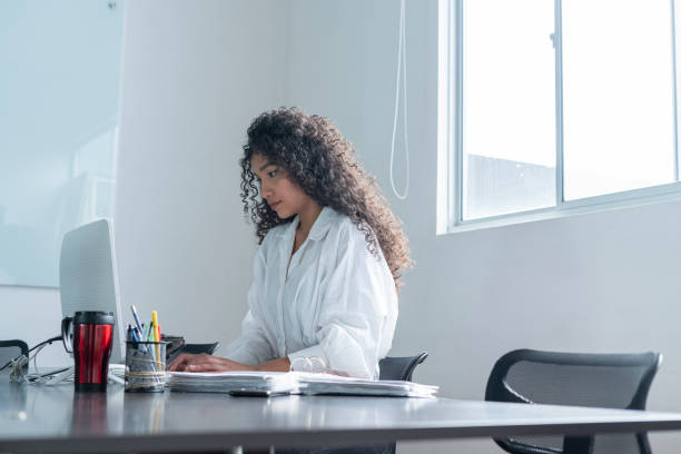 istock Latina businesswoman sitting at her workplace while enjoying her work and checking her computer 1314528023