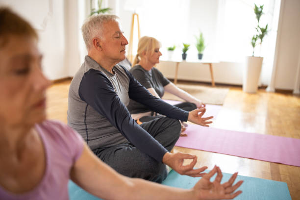 istock Senior man meditating during yoga class in yoga studio 1314528897