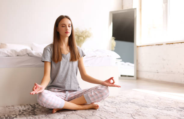 istock Young woman meditating  under bed in morning 1314532424