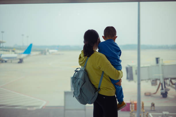 istock Mother with son looking out airport window 1314537525