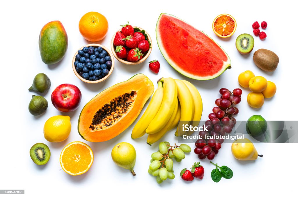 Multicolored fresh fruits on white background Overhead view of multicolored fresh ripe organic fruits shot on white background. The composition includes mango, orange, strawberry, blueberry, kiwi, peach, grape, watermelon, banana, papaya, apple, pear, fig, lime and lemon. High resolution 42Mp studio digital capture taken with SONY A7rII and Zeiss Batis 40mm F2.0 CF lens Fruit Stock Photo