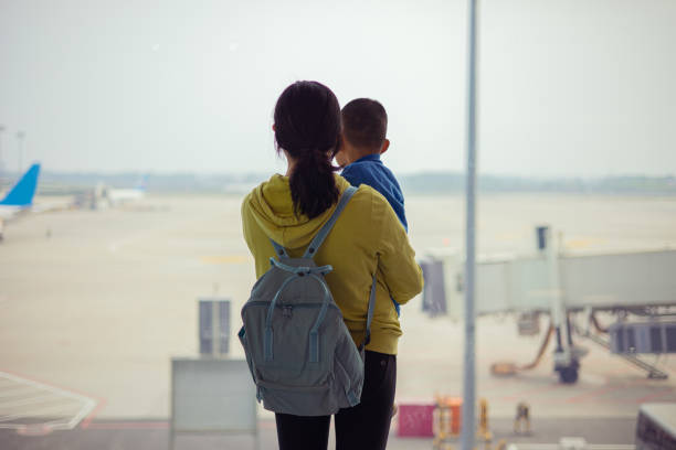 istock Mother with son looking out airport window 1314538574