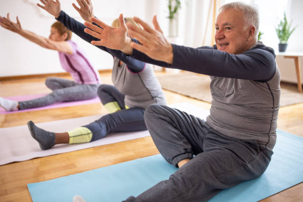 istock Senior man practicing yoga alongside senior women during yoga class 1314538736