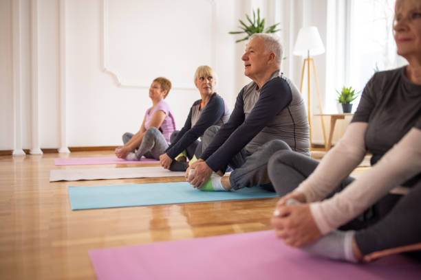 istock Senior man practicing yoga alongside senior women during yoga class 1314538780