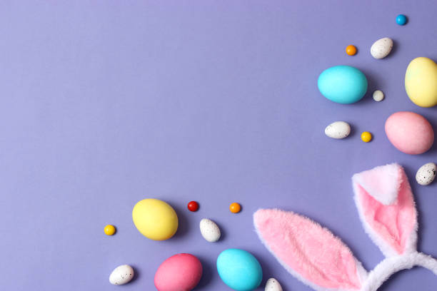 istock Easter composition of painted eggs and feathers on a colored background. 1314542438