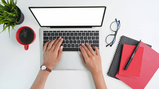 istock Top view workspace woman hands typing on mockup laptop computer with empty screen isolated display. 1314544019