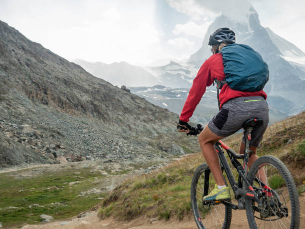istock Man mountain biker rides along trail below the Matterhorn mountain 1314547546