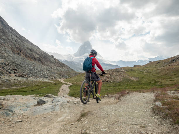 istock Man mountain biker rides along trail below the Matterhorn mountain 1314547549