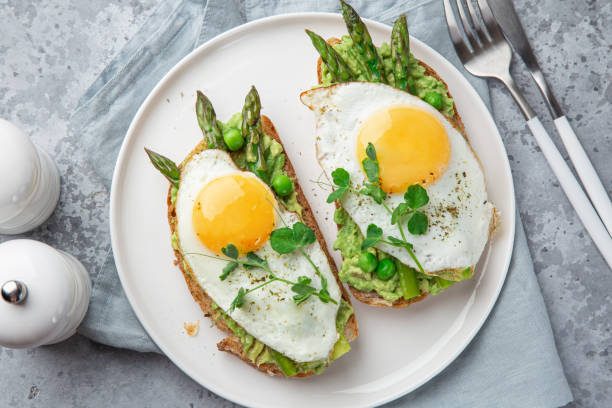 istock toasts with avocado, asparagus and fried egg on white plate 1314547733