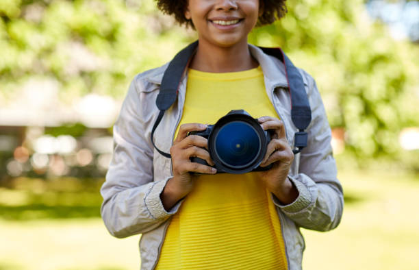 istock happy african woman with digital camera in park 1314547763