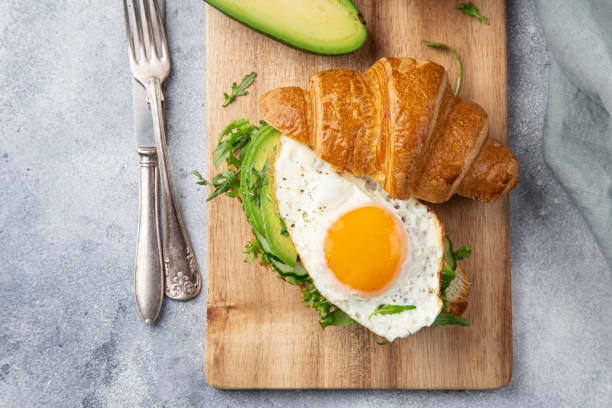 istock croissant sandwich with avocado, fried egg and arugula for breakfast 1314547798
