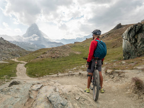 istock Man mountain biker contemplates the Matterhorn mountain 1314547800
