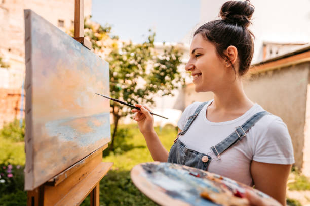 istock Female artist painting in backyard 1314548244