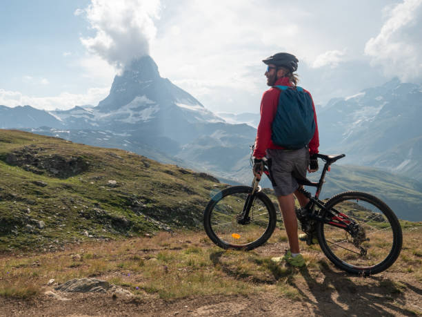 istock Man mountain biker rides along trail below the Matterhorn mountain 1314548357