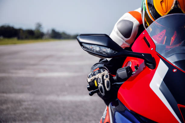 rider motorbike on the road riding with soft-focus and over light in the background rider motorbike on the road riding with soft-focus and over light in the background motorbike racing stock pictures, royalty-free photos & images